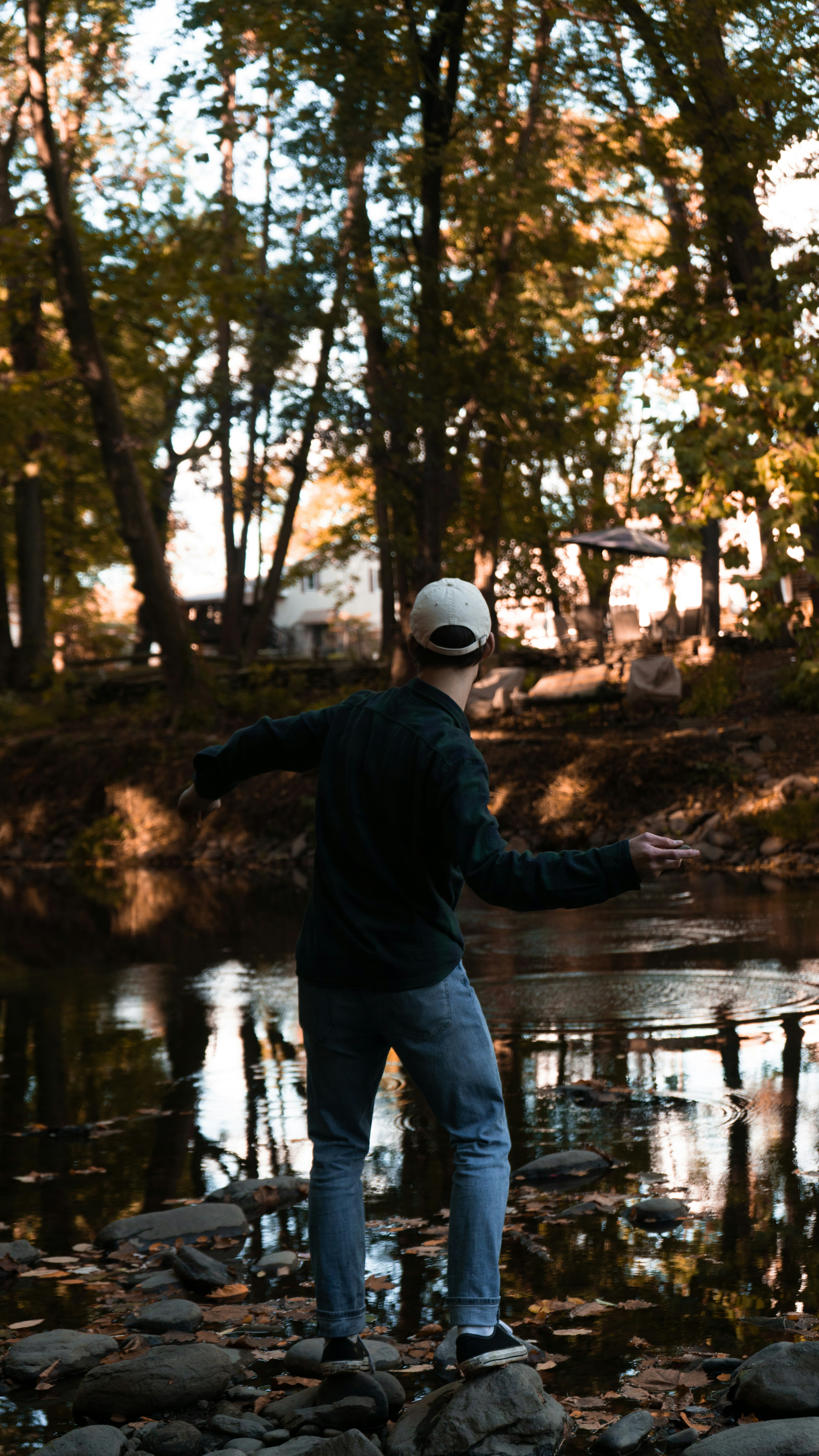 man in blue jacket and blue denim jeans standing on river during daytime